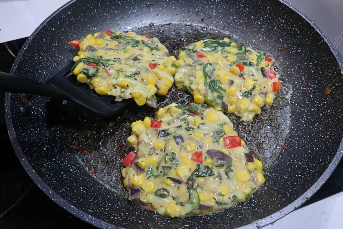 Flipping sweet corn and zucchini fritters
